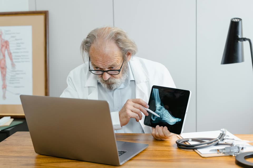Healthcare professional using a laptop during a patient consultation