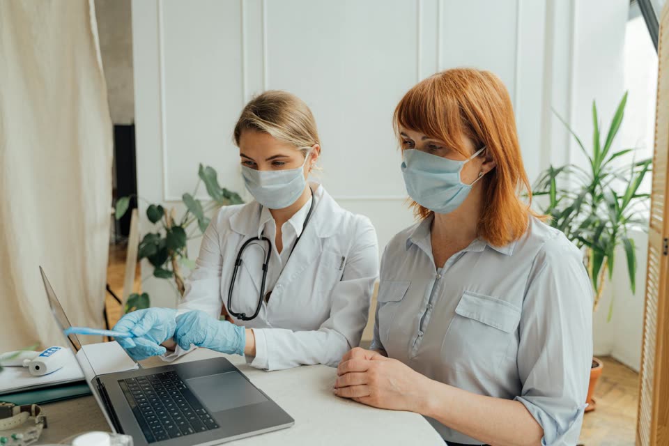 Doctor and patient reviewing a laptop screen during a consultation